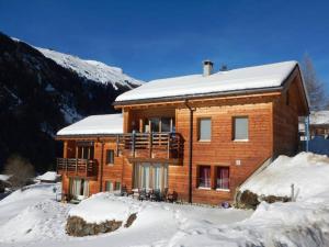 una casa in legno nella neve con la neve coperta di Ryad B Charmant et Chaleureux a Zinal