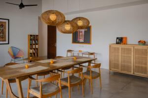 - une salle à manger avec une table et des chaises en bois dans l'établissement The Bed by The Sea, à Canggu