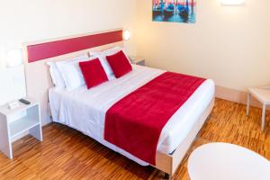 a hotel room with a large bed with red pillows at Hotel Autoespresso Venice - Atika & Atif in Marghera