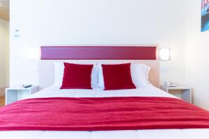 a bedroom with a large bed with red pillows at Hotel Autoespresso Venice - Atika & Atif in Marghera