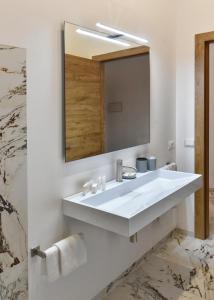 a bathroom with a white sink and a mirror at Hotel Exclusive in Agrigento