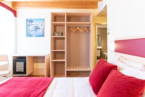 a bedroom with a large bed with red pillows at Hotel Autoespresso Venice - Atika & Atif in Marghera
