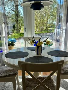 una mesa con dos sillas y un jarrón de flores. en Rymlig lägenhet i Stenungsund, en Stenungsund