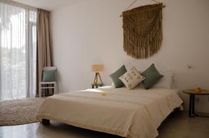 a bedroom with a large bed and a window at The Bed by The Sea in Canggu