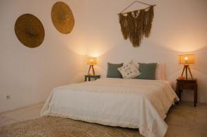 a bedroom with a bed and two lamps on the wall at The Bed by The Sea in Canggu