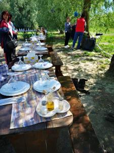 długi drewniany stół z talerzami żywności w obiekcie Hotel plutitor Sofia-Maria w mieście Uzlina