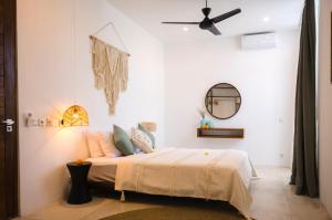 a bedroom with a bed with a ceiling fan at The Bed by The Sea in Canggu