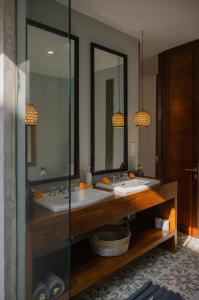 a bathroom with two sinks and two mirrors at The Bed by The Sea in Canggu