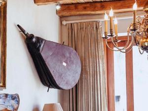 a shield hanging on a wall next to a curtain at De Kleijne Bos in Paarl