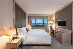 ein Hotelzimmer mit einem großen Bett und einem TV in der Unterkunft Renaissance Polat Istanbul Hotel in Istanbul