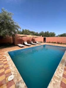 una gran piscina azul con tumbonas en un patio en Villa privative tortues2 piscine individual 35min, en Marrakech