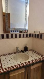 lavabo con espejo y encimera en Villa privative tortues2 piscine individual 35min, en Marrakech