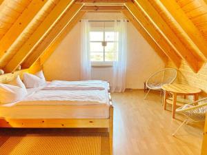 Schlafzimmer mit einem Bett, einem Fenster und einem Tisch in der Unterkunft Ferienhaus Eisvogel in Lübbenau