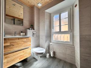ein Bad mit einem WC, einem Waschbecken und einem Fenster in der Unterkunft Le Pradet - Maison de ville rue piétonne animée in Clermont-Ferrand