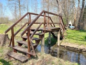 eine Holzbrücke über einen Fluss mit einer Brücke in der Unterkunft Ferienhaus Eisvogel in Lübbenau