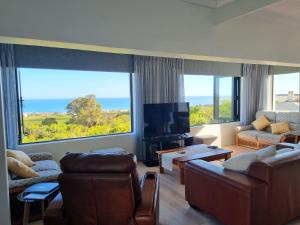 a living room with two couches and a large window at Deo-Lize in Bettyʼs Bay