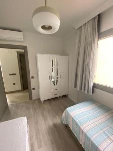 a small bedroom with a bed and a window at Moderne Villa in Kuşadası in Kuşadası