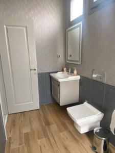 a bathroom with a white toilet and a sink at Moderne Villa in Kuşadası in Kuşadası