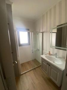 ein weißes Badezimmer mit einem Waschbecken und einem Spiegel in der Unterkunft Moderne Villa in Kuşadası in Kusadası