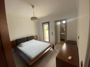 Schlafzimmer mit einem Bett, einem Tisch und einem Spiegel in der Unterkunft Moderne Villa in Kuşadası in Kusadası