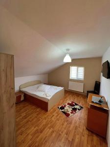 1 dormitorio con 1 cama con alfombra de vaca en el suelo en Casa NIB Calimanesti en Călimăneşti