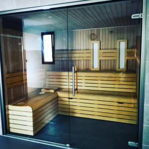 um quarto com uma sauna com uma parede de vidro em La cabane 27 ~ Chalet cosy au bord du lac de Peyre em Labouheyre