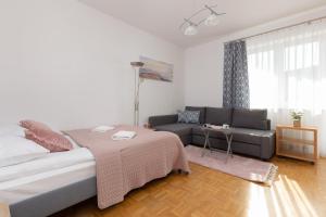 een woonkamer met een bed en een bank bij Metro Natolin Ursynów Centre Studio with Balcony by Renters in Warschau