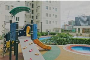 a playground with a slide in a pool at Homey 2 BR Unit w/Pool in Avida IT Park in Cebu City
