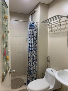 een badkamer met een toilet, een douche en een wastafel bij Homey 2 BR Unit w/Pool in Avida IT Park in Cebu City