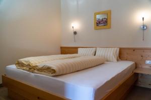 a bed in a bedroom with two lights on the wall at Chalet Alpenblick in Fiss