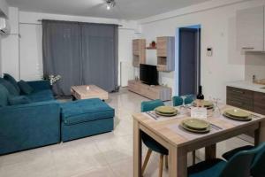 a living room with a blue couch and a table at Modern spacious apartment located in Piraeus (B8) in Piraeus