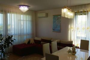 uma sala de estar com um sofá e uma mesa em Прекрасный апартамент с видом на море и бассейном em Byala