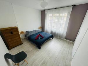 1 dormitorio con 1 cama, vestidor y silla en L'appartement Lafayette rive gauche en Rouen