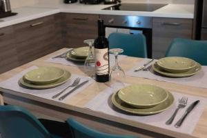 een tafel met groene borden en een fles wijn bij Modern spacious apartment located in Piraeus (B8) in Piraeus