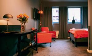 Narvik Hotel Wivel في نارفيك: غرفة في الفندق بها سرير و مزهرية من الزهور