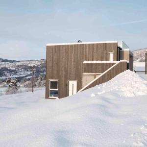 un edificio con un montón de nieve delante de él en Apartment in Hafjell / Øyer centre., en Hafjell