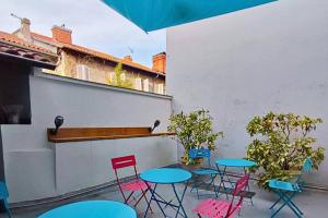 a patio with tables and chairs and an umbrella at La Villa Loha - Maison De Vacances in Saint-Gaudens