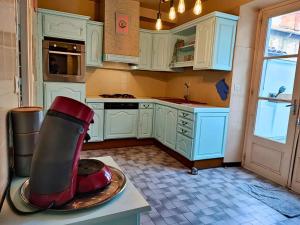 a kitchen with white cabinets and a red appliance on a counter at La Villa Loha - Maison De Vacances in Saint-Gaudens