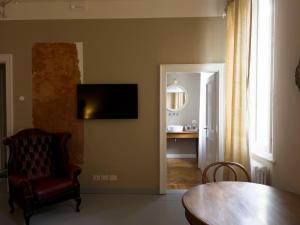 sala de estar con mesa y TV en la pared en CasaZavi, en Belluno