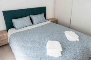 a bedroom with a large bed with towels on it at Modern spacious apartment located in Piraeus (B8) in Piraeus