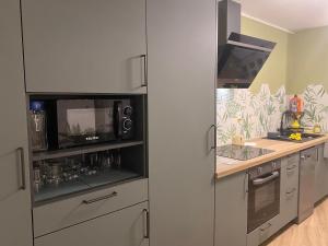 a kitchen with a microwave and a stove top oven at Le Nid Vert in La Possession +12 photos