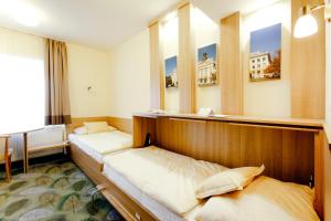 duas camas num quarto com duas janelas em Aranyhomok Business-City-Wellness Hotel em Kecskemét