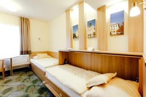 Aranyhomok Business-City-Wellness Hotel في كيسكيميت: سريرين في غرفة بها نافذتين