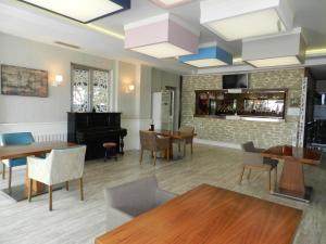 un restaurante con piano, mesas y sillas en Sefa Hotel 2 Çorlu en Corlu