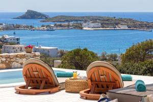 a table and chairs on a patio with a view of the ocean at Syros Grace eco-Villa with Jacuzzi & Stuning Views in Ano Syros