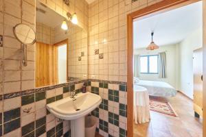 uma casa de banho com um lavatório, um espelho e uma cama em Casa Ágave em El Pozo de los Frailes