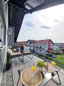 un patio con mesas y sillas en el balcón en Apartments Gradiska en Bosanska Gradiška