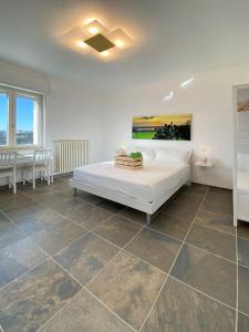 Schlafzimmer mit einem großen weißen Bett und Fliesenböden in der Unterkunft L'altra LulÍa in Otranto