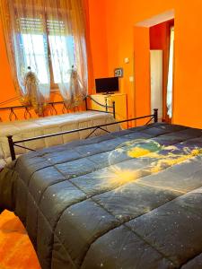 een slaapkamer met 2 bedden en oranje muren bij Agriturismo il Portico in Capalbio