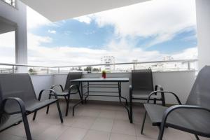 een patio met een tafel en stoelen op een balkon bij Modern spacious apartment located in Piraeus (B8) in Piraeus